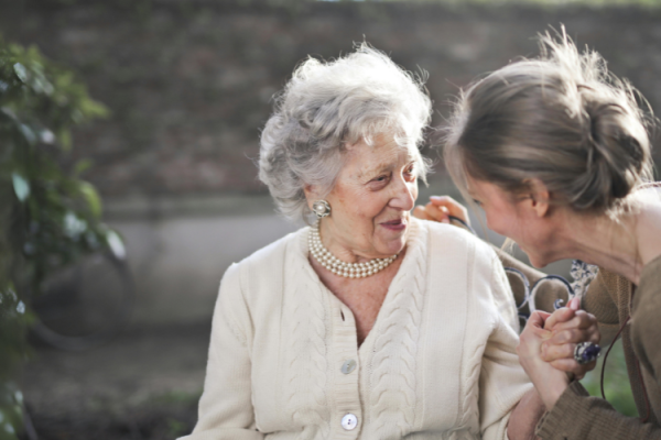 Oude vrouw en vrouw van middelbare leeftijd met elkaar in gesprek