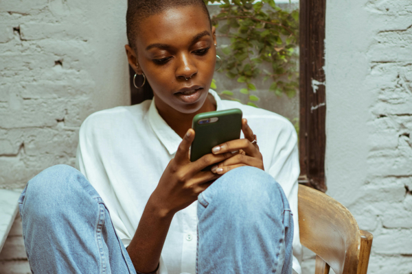 Vrouw met telefoon op stoel