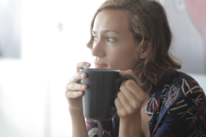 Afbeelding van een vrouw die op de bank zit met een kop thee