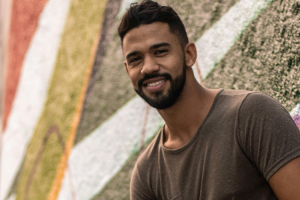 Man in T-shirt voor een muur met muurschilderingen