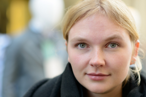 Jong persoon met lichtblond haar kijkt recht de camera in